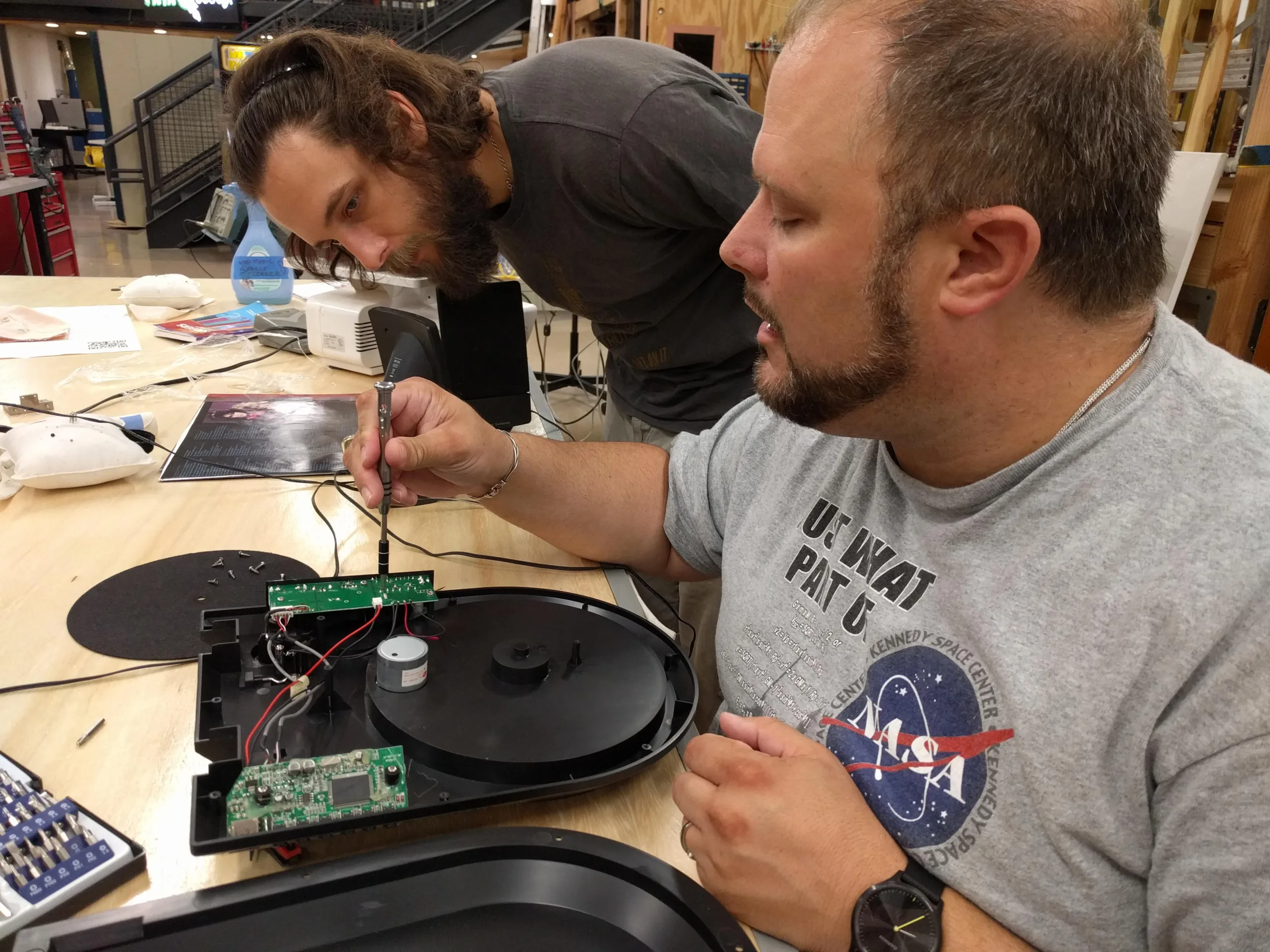 Two members work on an electronics project